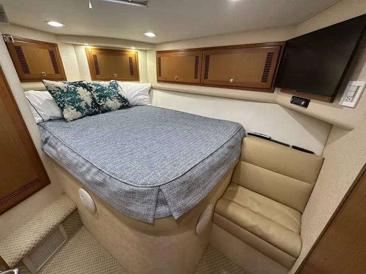 Off Season Yacht Photos Pics Luxurious cabin interior of 2006 Cabo 48 Convertible yacht with bed and TV.