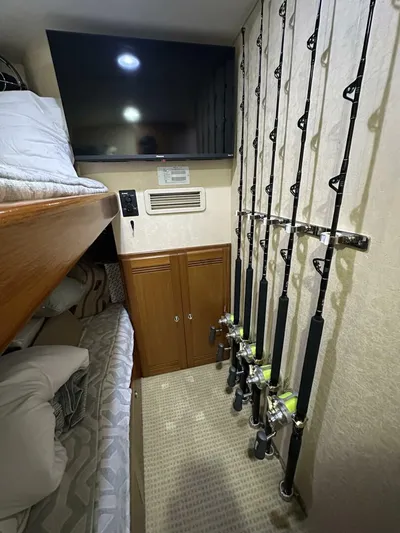 Off Season Yacht Photos Pics Interior of 2006 Cabo 48 Convertible with fishing rods, bunk beds, and TV.