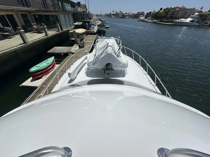 Off Season Yacht Photos Pics 2006 Cabo 48 Convertible yacht docked in a scenic marina.