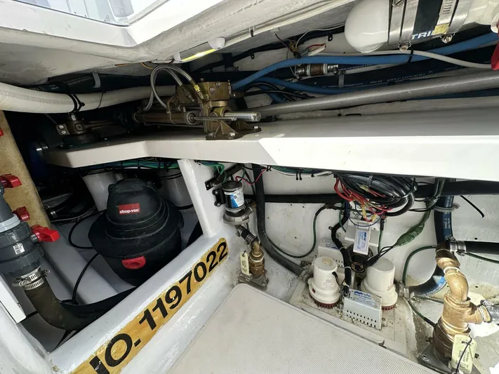 Off Season Yacht Photos Pics Engine room of 2006 Cabo 48 Convertible boat with mechanical components and wiring.