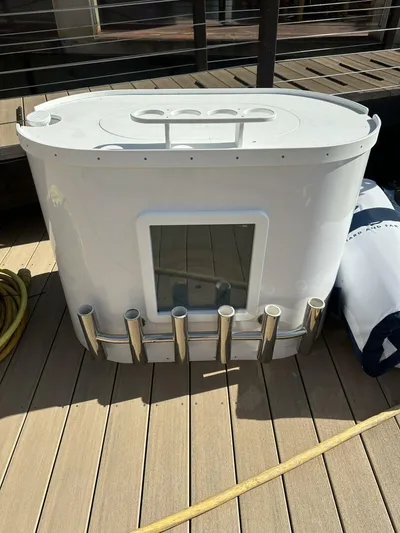 Off Season Yacht Photos Pics 2006 Cabo 48 Convertible boat accessory on wooden deck, featuring rod holders and storage compartment.