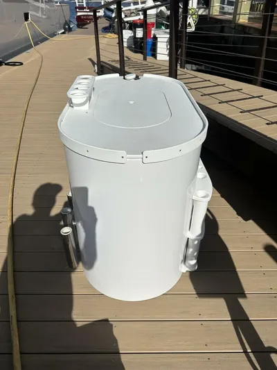 Off Season Yacht Photos Pics White cylindrical container on a wooden dock, near a Cabo 48 Convertible yacht.