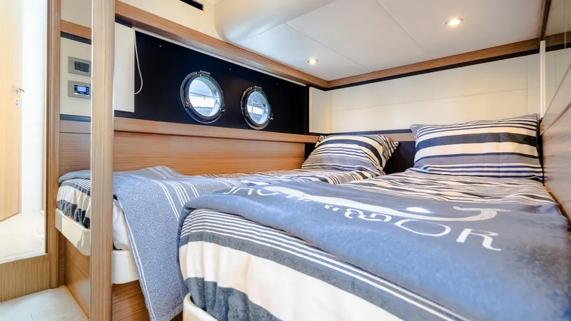 O Sea D Yacht Photos Pics Interior cabin of 2017 Absolute 50 Fly yacht with striped bedding and porthole windows.