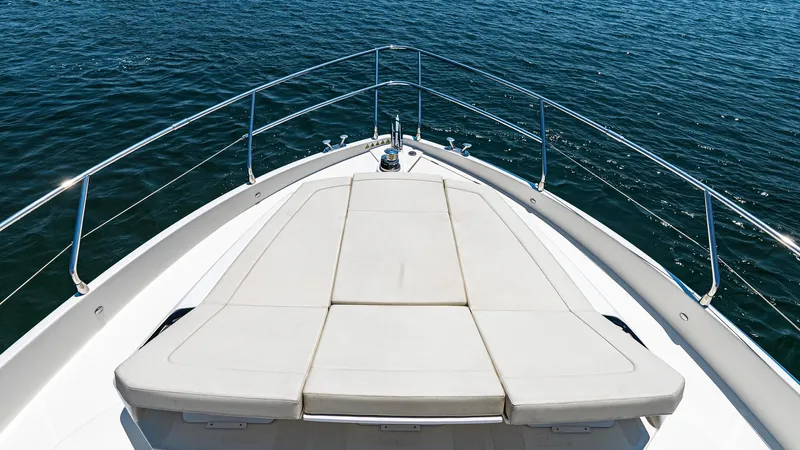 O Sea D Yacht Photos Pics Bow view of 2017 Absolute 50 Fly yacht with sunbed, surrounded by calm blue water.