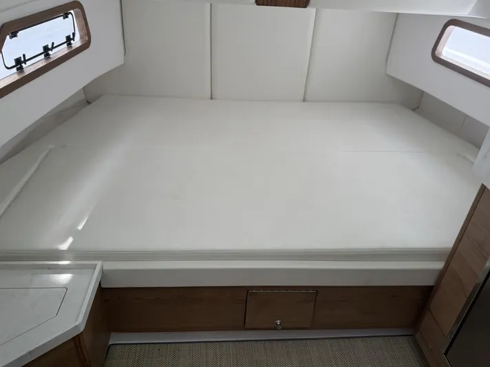  Yacht Photos Pics 2023 Bertram 39 CC cabin interior with spacious bed and wooden accents.