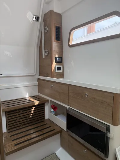  Yacht Photos Pics Interior of 2023 Bertram 39 CC boat with wooden cabinetry and modern appliances.