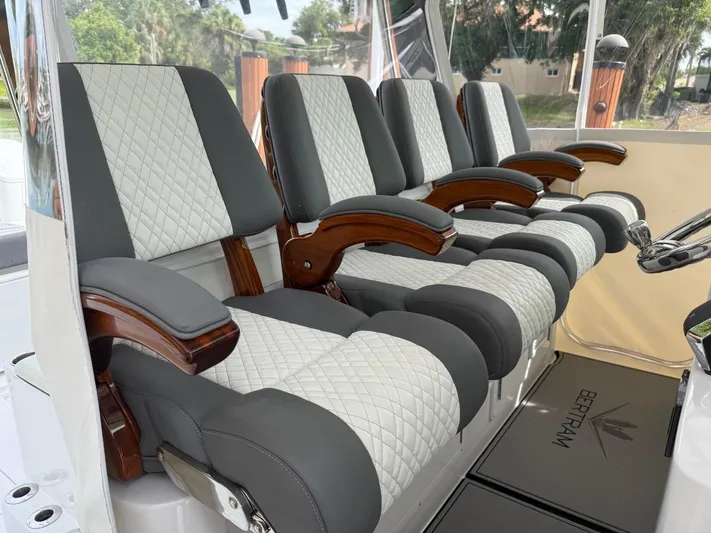  Yacht Photos Pics Luxurious seating on 2023 Bertram 39 CC boat, featuring quilted upholstery and wooden armrests.