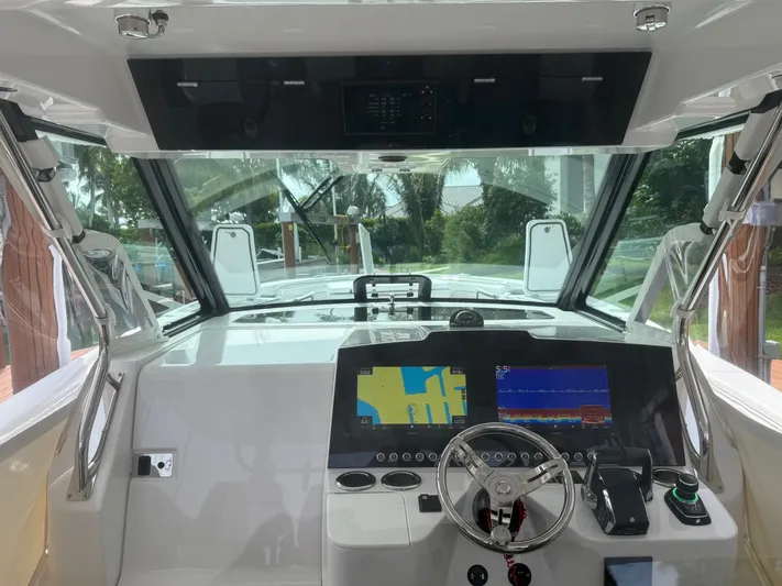  Yacht Photos Pics 2023 Bertram 39 CC boat cockpit with advanced navigation displays and steering wheel.