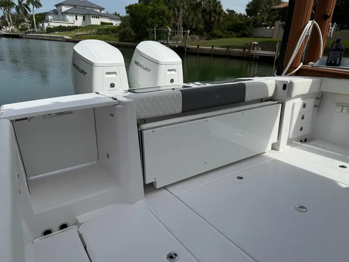  Yacht Photos Pics 2023 Bertram 39 CC boat deck with Mercury engines, docked near waterfront homes.