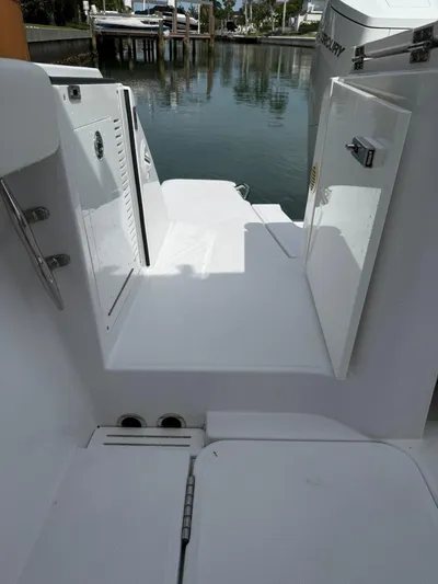  Yacht Photos Pics 2023 Bertram 39 CC boat deck with open storage compartments by the water.