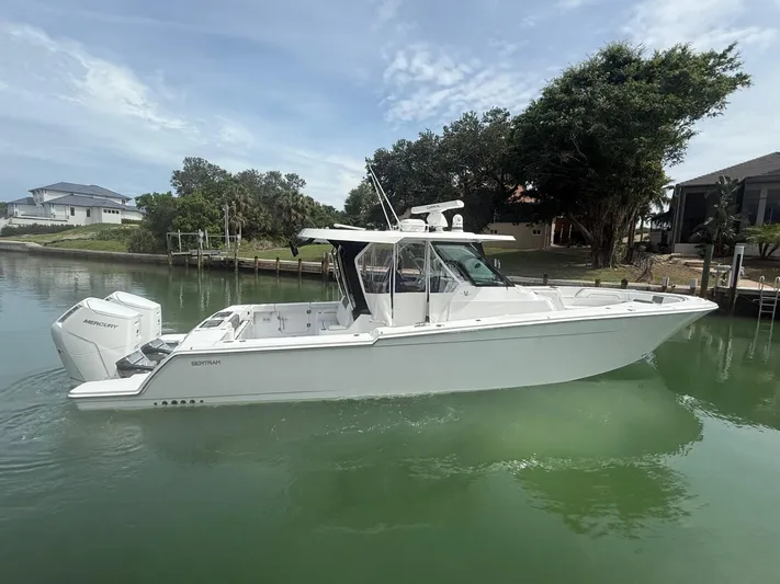  Yacht Photos Pics 2023 Bertram 39 CC boat on calm water, featuring sleek design and twin Mercury engines.