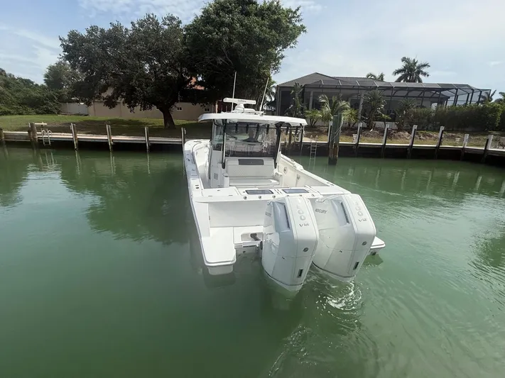  Yacht Photos Pics 2023 Bertram 39 CC boat with twin Mercury engines docked in calm waters.