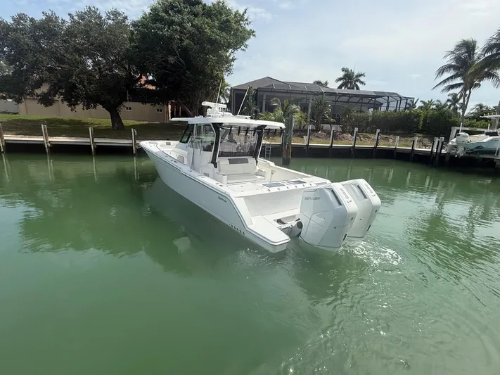  Yacht Photos Pics 2023 Bertram 39 CC boat with dual Mercury engines docked in a serene marina.
