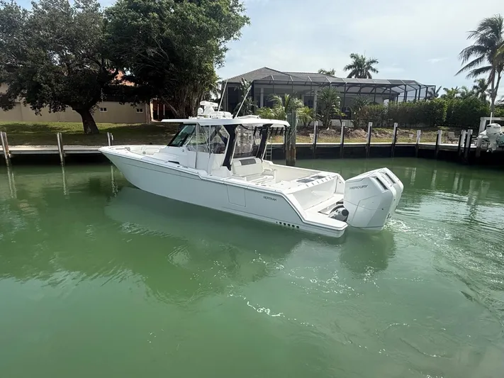  Yacht Photos Pics 2023 Bertram 39 CC boat with twin Mercury engines in a serene marina setting.
