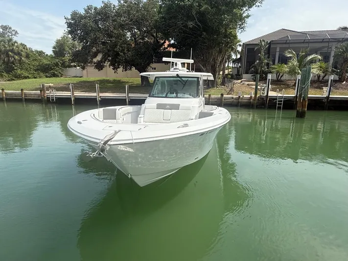  Yacht Photos Pics 2023 Bertram 39 CC boat docked in calm waters near a residential area.