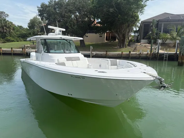  Yacht Photos Pics 2023 Bertram 39 CC boat docked in a serene waterfront setting.