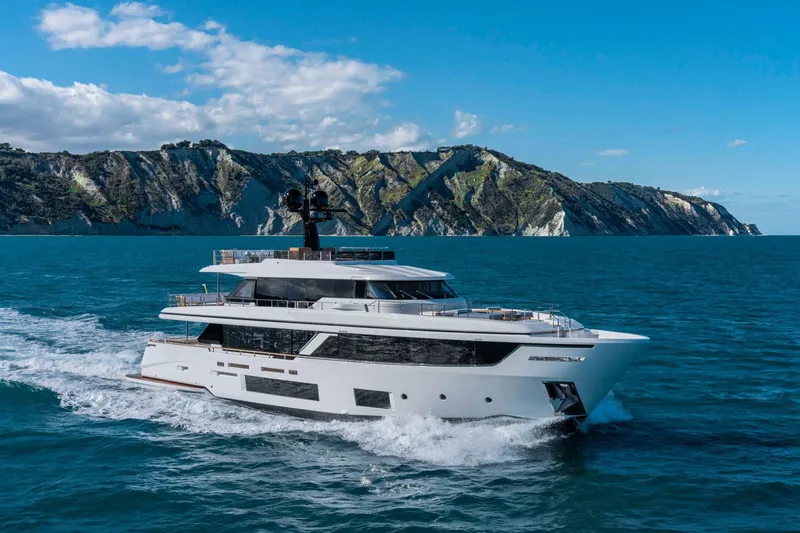  Yacht Photos Pics Luxurious 2023 Custom Line Navetta 30 yacht cruising near scenic cliffs.