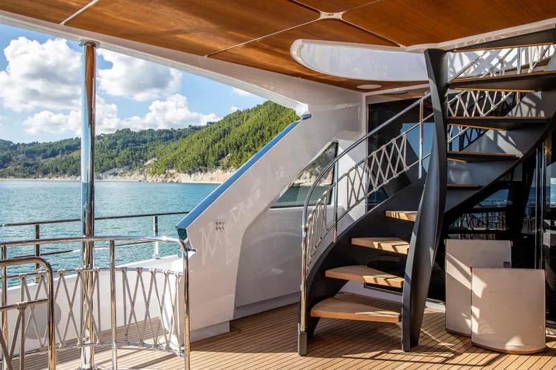  Yacht Photos Pics Luxurious 2023 Custom Line Navetta 30 yacht with elegant spiral staircase and scenic ocean view.
