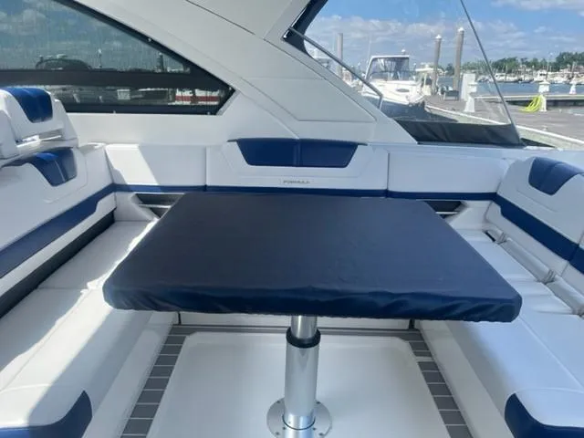  Yacht Photos Pics Interior seating area of a 2022 Formula 400 Super Sport Crossover boat with a central table.