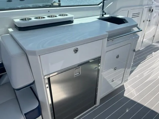  Yacht Photos Pics 2022 Formula 400 Super Sport Crossover yacht interior with kitchenette and stainless steel fridge.