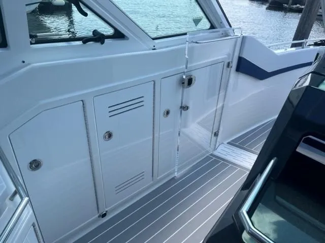  Yacht Photos Pics 2022 Formula 400 Super Sport Crossover boat interior with white cabinetry and glass door.