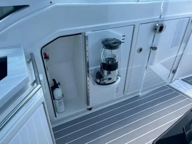  Yacht Photos Pics 2022 Formula 400 Super Sport Crossover boat storage compartment with fire extinguisher and lantern.