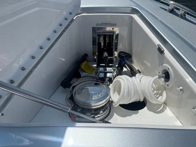  Yacht Photos Pics 2022 Formula 400 Super Sport Crossover boat storage compartment with coiled hose and equipment.