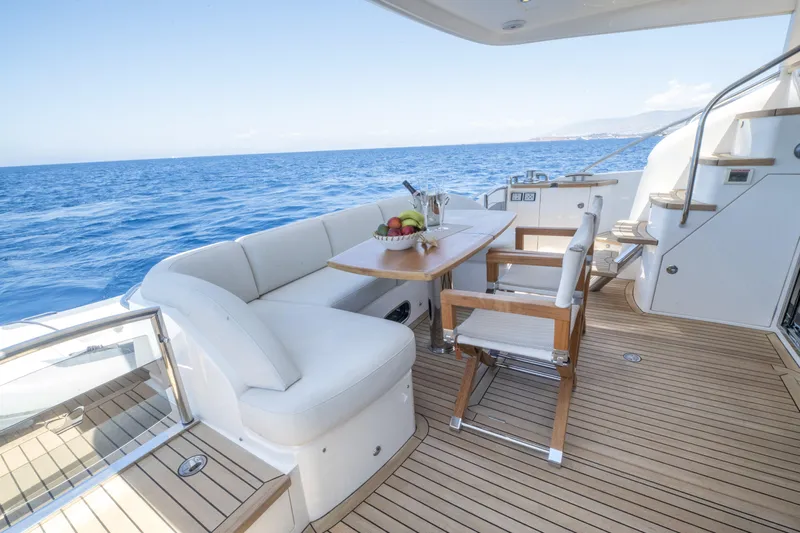  Yacht Photos Pics Luxurious 2014 Princess 56 yacht deck with seating, table, and ocean view.
