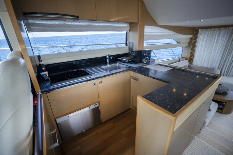  Yacht Photos Pics Luxurious yacht kitchen interior with modern appliances, wood cabinetry, and ocean view. Princess 56, 2014.
