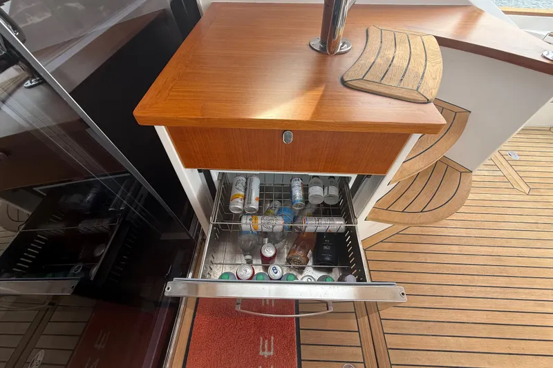 Habibi Yacht Photos Pics Open drawer with beverages on a 2017 Belize 54 Daybridge yacht, featuring wooden flooring.