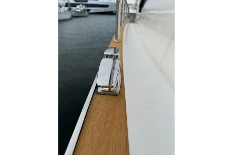 Habibi Yacht Photos Pics Close-up of 2017 Belize 54 Daybridge yacht deck with chrome cleat and wooden finish.