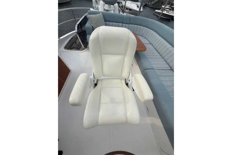 Habibi Yacht Photos Pics Luxurious seating on 2017 Belize 54 Daybridge yacht, featuring white captain's chair and cushioned bench.