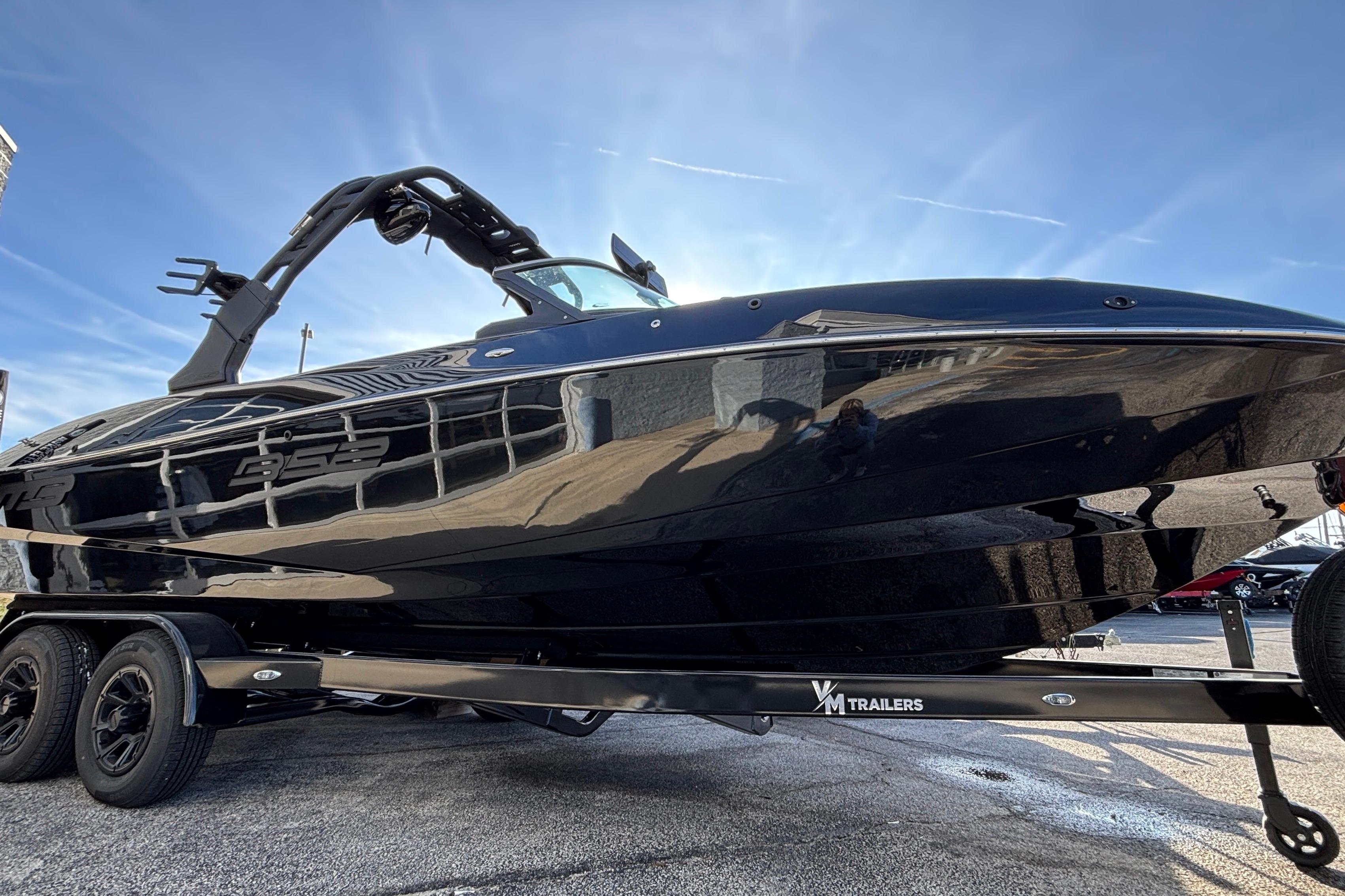 2026 MB B52 23 Classic boat on trailer, sleek black design under clear blue sky.