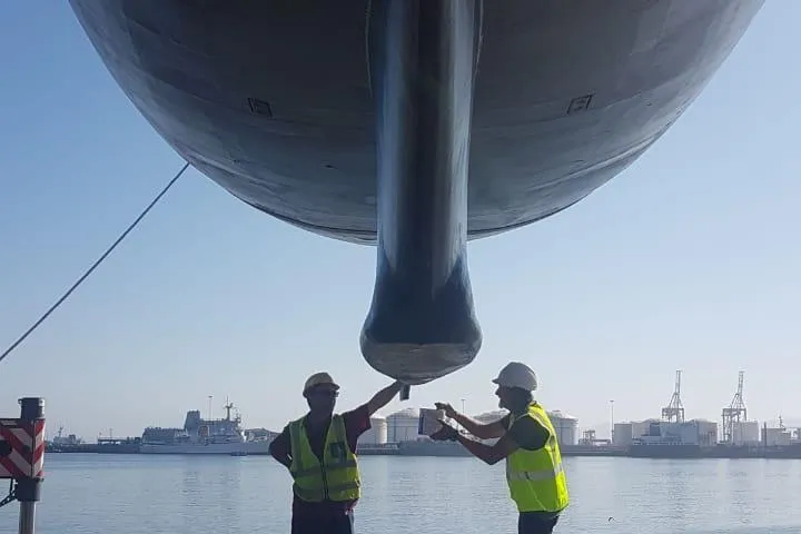 Espresso Yacht Photos Pics Two workers inspecting the hull of a 2019 Southwell Sovereign 51 yacht at a dock.