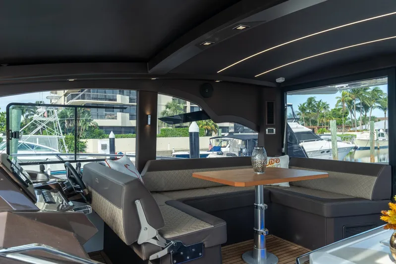  Yacht Photos Pics Interior of 2022 Galeon 425 HTS yacht with modern seating and table, docked at marina.