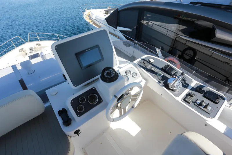  Yacht Photos Pics Helm of 2019 Azimut Magellano 53 yacht with navigation controls and steering wheel.