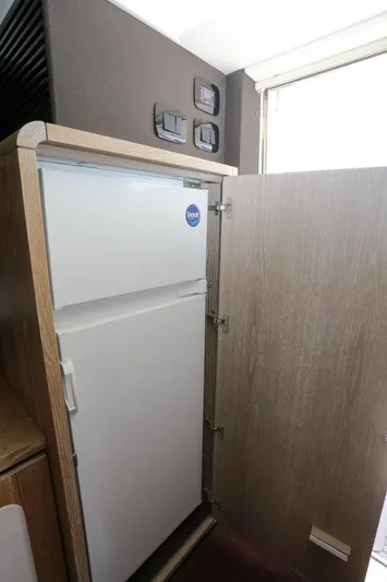  Yacht Photos Pics 2019 Azimut Magellano 53 yacht interior with built-in refrigerator and wooden cabinetry.