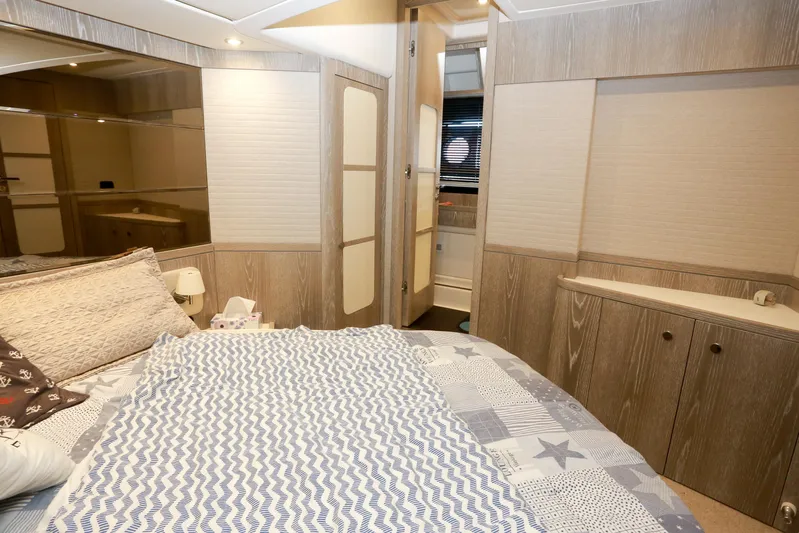  Yacht Photos Pics Luxurious bedroom interior of 2019 Azimut Magellano 53 yacht with modern wood finishes.