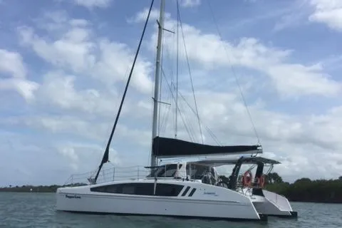 Pepper Love Yacht Photos Pics 2020 Seawind 1190 Sport catamaran sailing on calm waters under a cloudy sky.