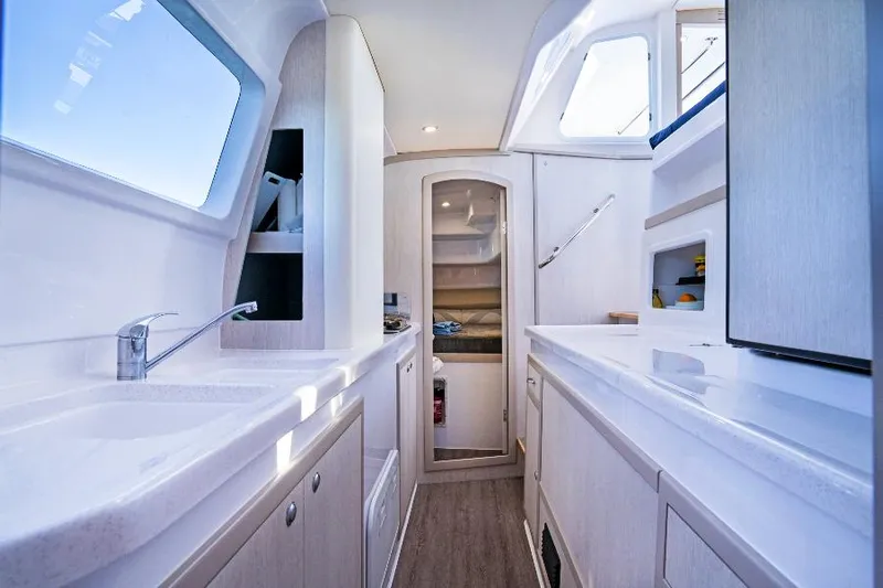 Pepper Love Yacht Photos Pics Modern galley kitchen in 2020 Seawind 1190 Sport catamaran with sleek white cabinetry.