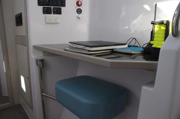Pepper Love Yacht Photos Pics Interior workspace of 2020 Seawind 1190 Sport catamaran with desk and blue seat.