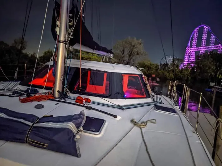 Pepper Love Yacht Photos Pics 2020 Seawind 1190 Sport sailboat docked at night with amusement park lights in background.