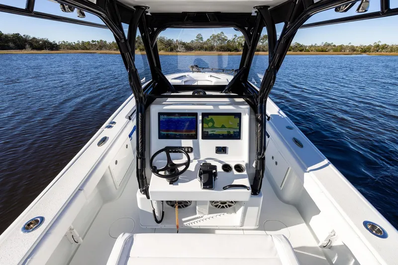  Yacht Photos Pics 2023 Yellowfin 32 Offshore boat interior with navigation system on calm water.