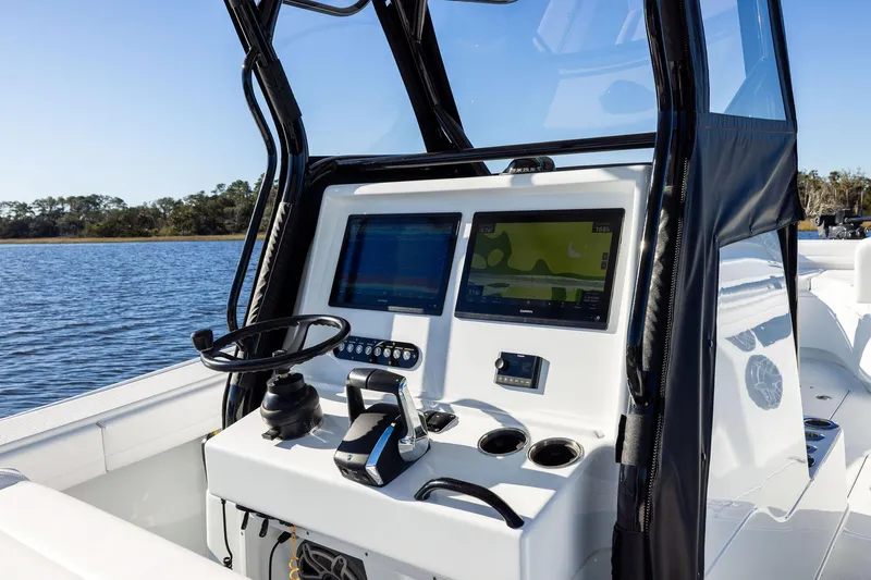  Yacht Photos Pics 2023 Yellowfin 32 Offshore boat console with dual navigation screens on calm water.