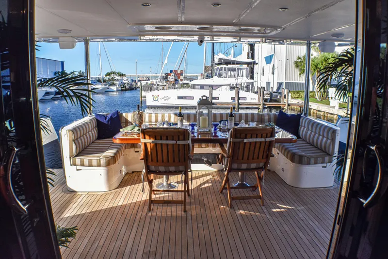 Magic Moments Yacht Photos Pics Luxurious yacht deck dining area with striped seating, wooden table, and marina view. Johnson Country Kitchen 2006.