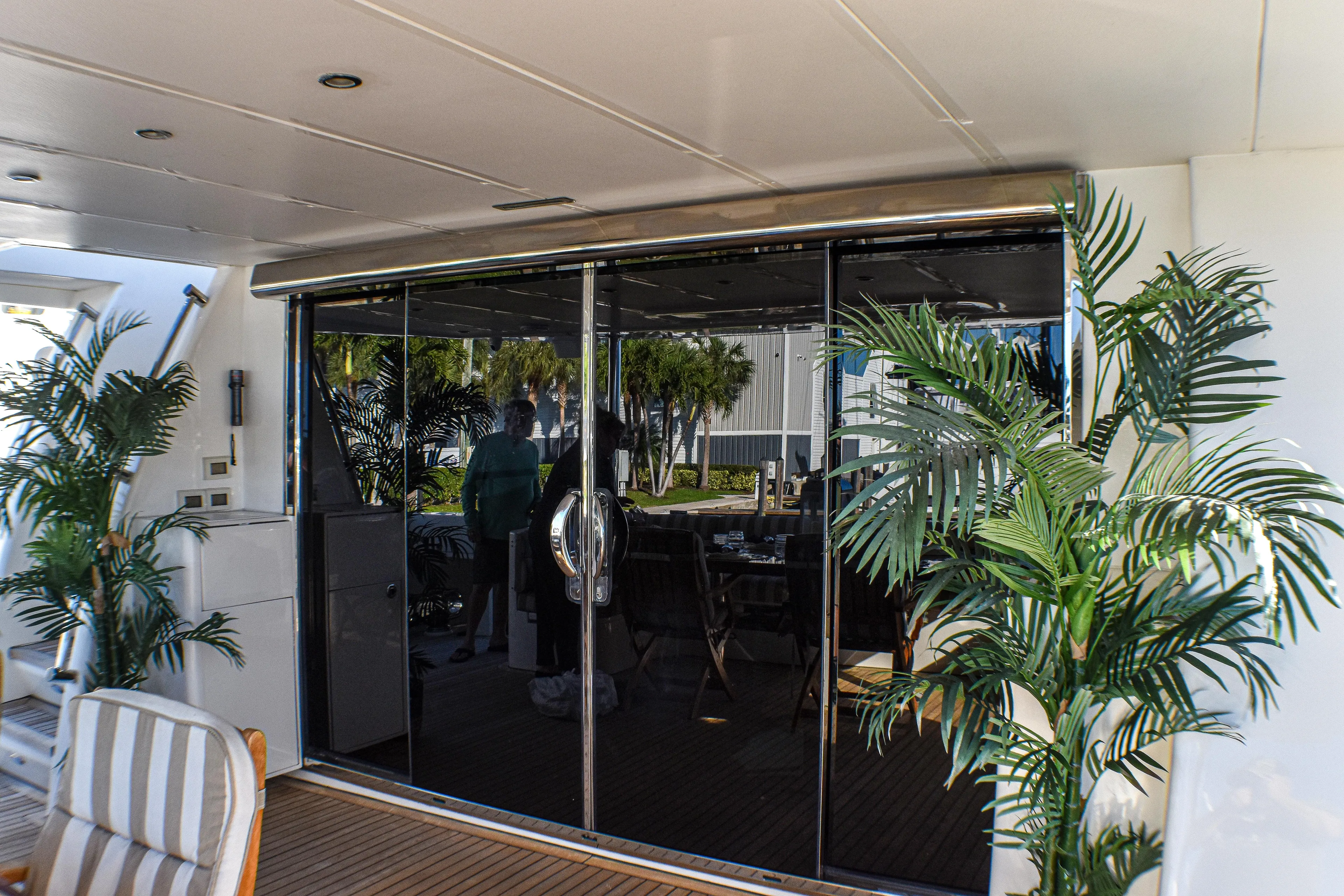 Magic Moments Yacht Photos Pics Luxurious yacht interior with glass doors, tropical plants, and striped seating, Johnson Country Kitchen 2006 model.