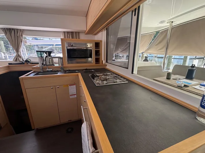 Serenity Yacht Photos Pics Modern kitchen interior of 2016 Lagoon 400 S2 catamaran with stove and oven.