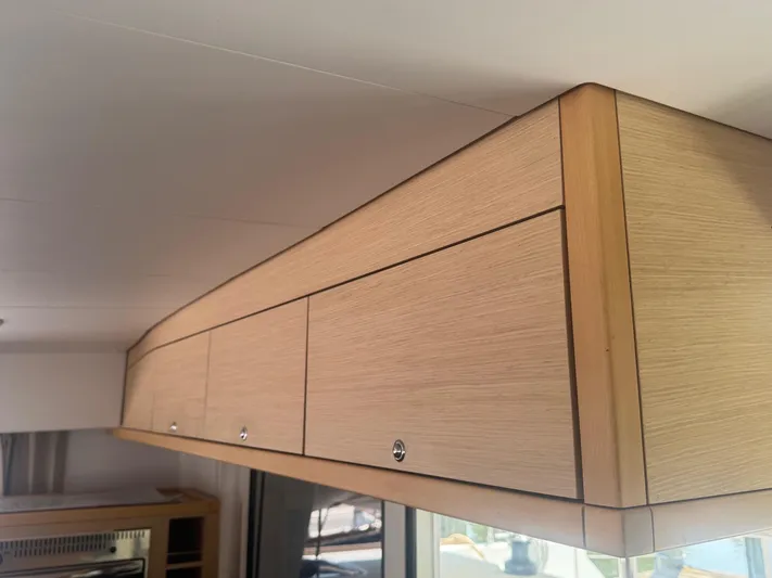 Serenity Yacht Photos Pics Wooden cabinetry inside a 2016 Lagoon 400 S2 catamaran, showcasing sleek design and ample storage.