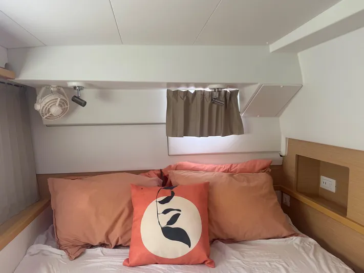 Serenity Yacht Photos Pics Cozy cabin bedroom in 2016 Lagoon 400 S2 catamaran with decorative pillows and fan.
