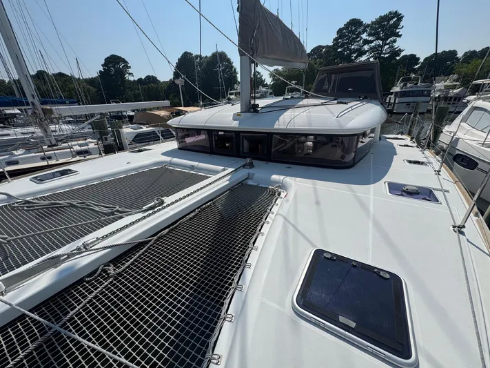Serenity Yacht Photos Pics 2016 Lagoon 400 S2 catamaran docked at marina, featuring spacious deck and netting.